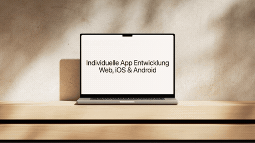 Laptop auf Holztisch mit Schriftzug Individuelle App-Entwicklung für Web, iOS und Android